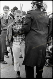 Young skinhead demonstrator being searched by police at Anti-NF